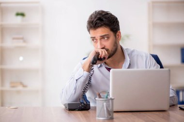 Genç çalışan işyerinde oturuyor.