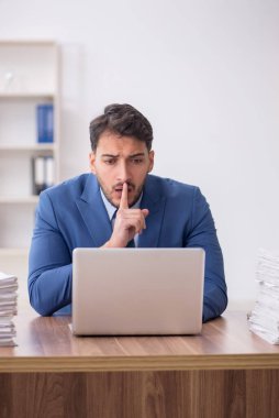 Young employee and too much work at workplace