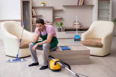 Genç müteahhit evi temizliyor.