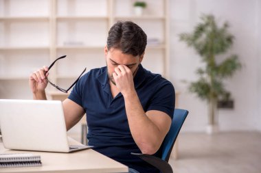 Genç çalışan işyerinde oturuyor.