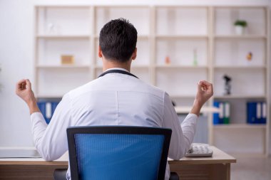 Hastanede çalışan genç erkek doktor.