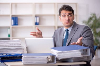 Young employee and too much work at workplace