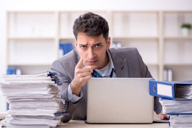 Young employee and too much work at workplace