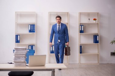 Genç işadamı ve işyerinde çok fazla iş var.