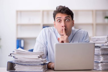 Young employee and too much work at workplace