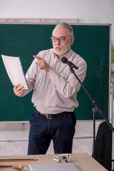 Old music teacher in the classroom