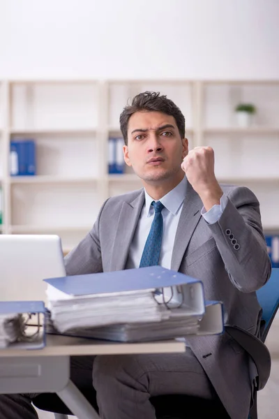 stock image Young employee and too much work at workplace