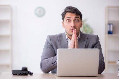 Young employee and too much work at workplace