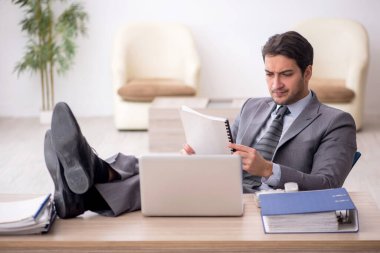 Genç çalışan işyerinde oturuyor.