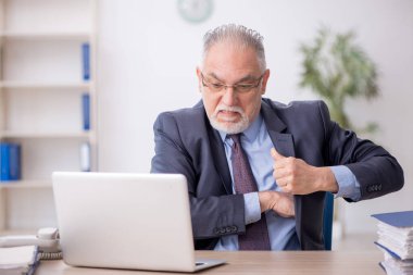 Old employee working at workplace