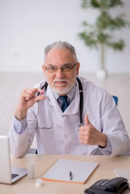 Old doctor suggesting pills at the hospital