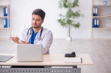 Genç doktor klinikte hap öneriyor.