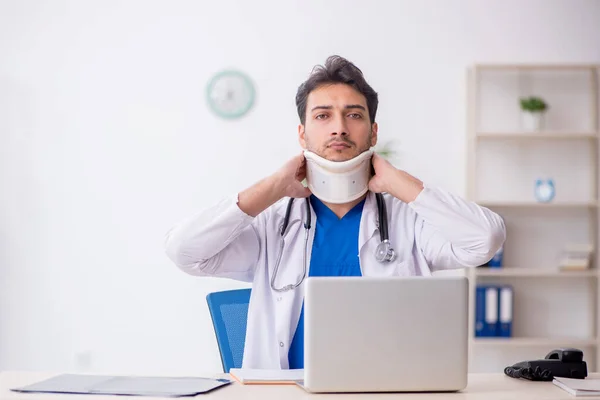 Young doctor holding neck brace in the clinic