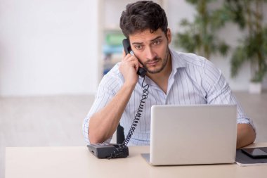 Genç çalışan işyerinde oturuyor.