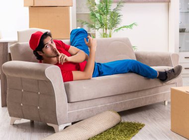 İçeride çalışan kutularla çalışan genç bir erkek müteahhit.