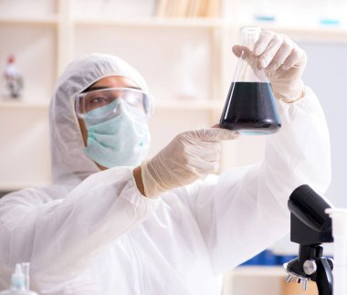 Laboratuvarda çalışan genç yakışıklı kimyager.