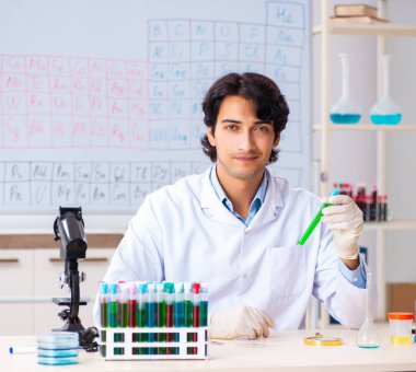 Laboratuvarda çalışan genç kimyager.