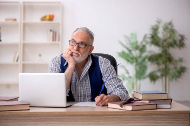 İş yerinde oturan yaşlı yazar.