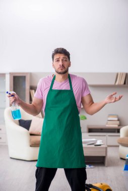 Genç müteahhit evi temizliyor.