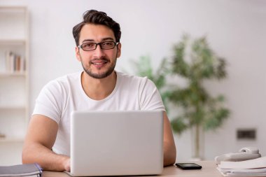 Genç çalışan işyerinde oturuyor.