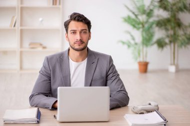 Genç çalışan işyerinde oturuyor.