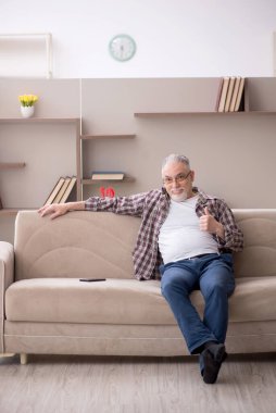 Old man sitting at home during pandemic