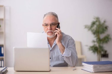 Old employee working at workplace