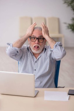 Old employee working at workplace