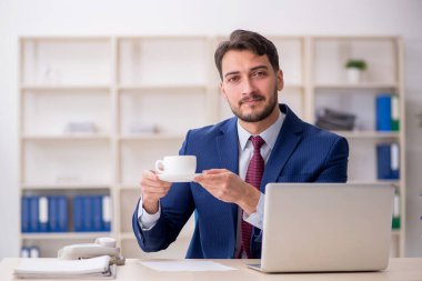 Molada kahve içen genç bir çalışan.