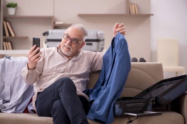 Aged man preparing for trip at home