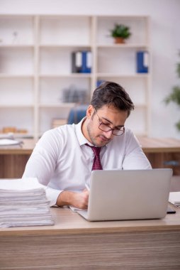 Genç işadamı işyerinde oturuyor.