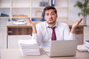 Genç işadamı işyerinde oturuyor.