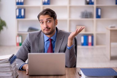 Genç işadamı işyerinde oturuyor.