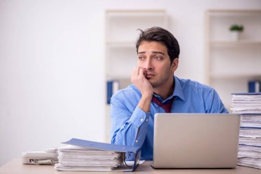 Genç işadamı ve ofiste çok fazla iş var.