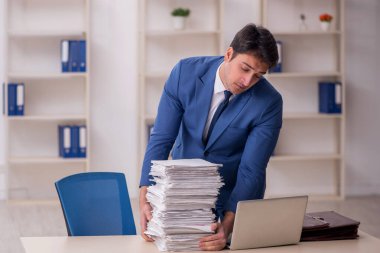 Genç işadamı ve işyerinde çok fazla iş var.