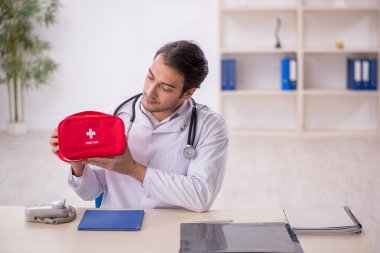 İlk yardım çantasını tutan genç doktor.