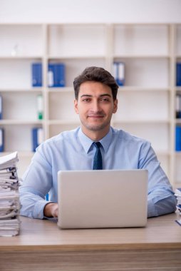 Young employee and too much work at workplace