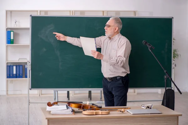 Old music teacher in the classroom
