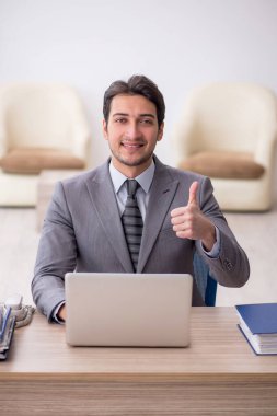 Genç çalışan işyerinde oturuyor.