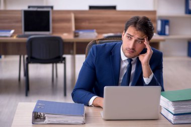 Genç işadamı ve işyerinde çok fazla iş var.