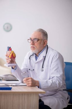 Klinikte çalışan yaşlı bir kardiyolog.