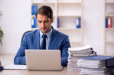 Genç işadamı ve ofiste çok fazla iş var.