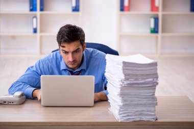 Genç işadamı ve ofiste çok fazla iş var.