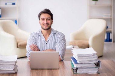 Young employee and too much work at workplace