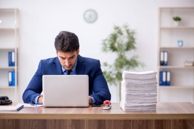 Genç bir çalışan ve ofiste çok fazla iş var.