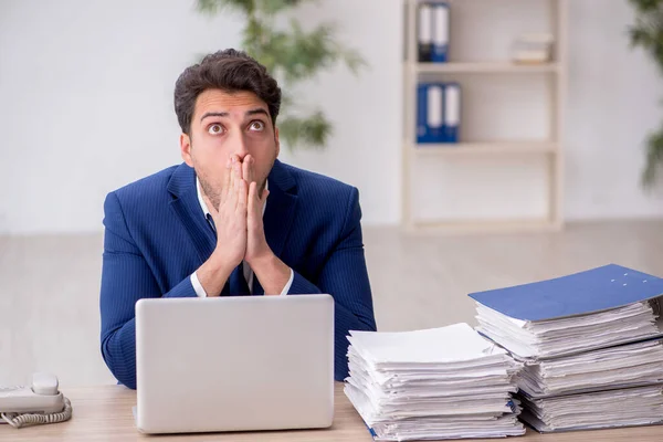 stock image Young employee unhappy with excessive work in the office