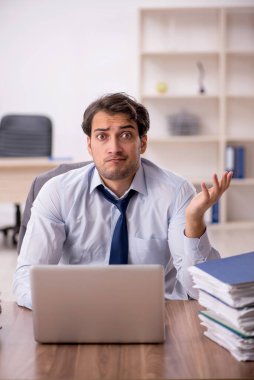 Genç işadamı ve işyerinde çok fazla iş var.