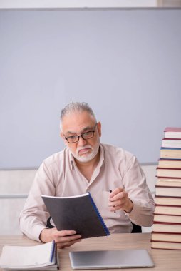 Old teacher sitting in the classroom