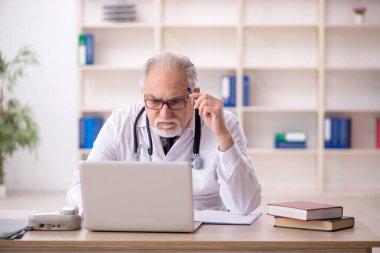 Teletıp konseptinde yaşlı erkek doktor