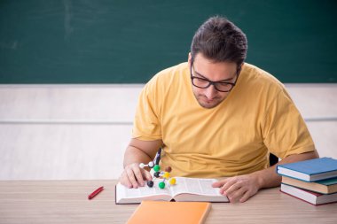 Young student physicist sitting in the classroom